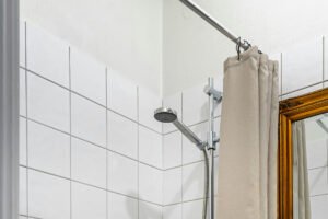 Klammern befestigen einen Duschvorhang an der Badewannenwand