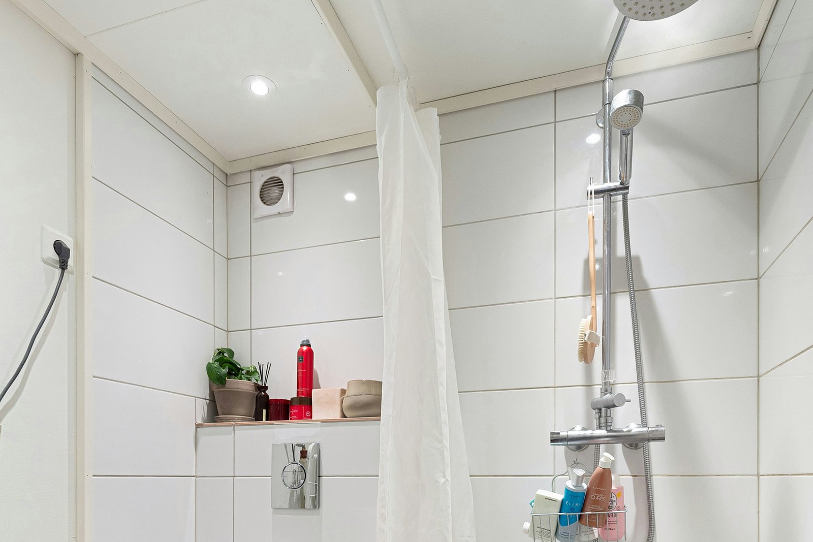 Dünner Duschvorhang hängt leicht in einer Dusche